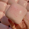 Pinkes, quetschbares Plastikbrot-Fidget-Spielzeug in der Hand, zeigt Textur und sprenkelte Oberfläche.