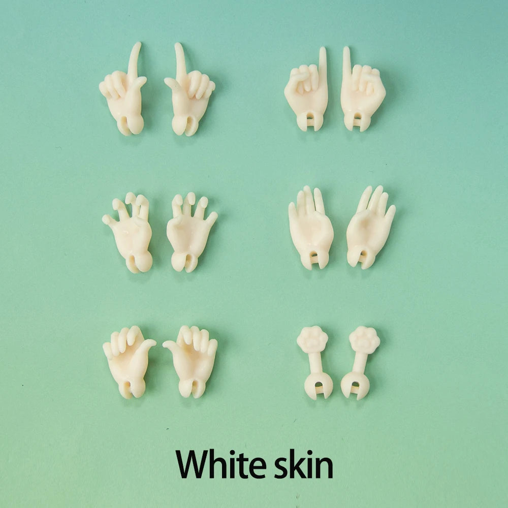A collection of white, articulated doll hands and fingers displayed against a light green background.