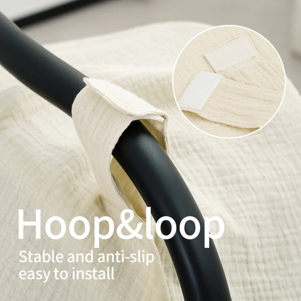 Close-up of a black hoop and loop strap used to secure a beige muslin car seat cover.