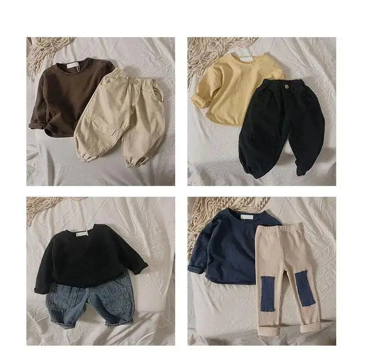 A collection of kids long sleeve cotton tees in various solid colors and neutral tones.