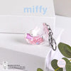 A pink glass charm featuring a white Miffy rabbit is displayed on a white gift box.