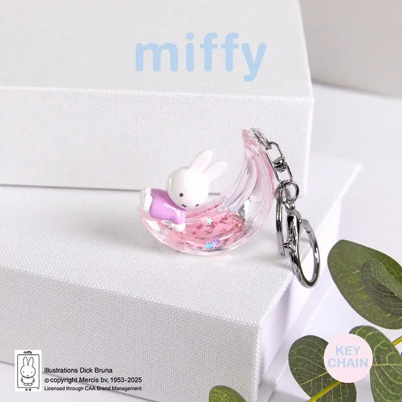 A pink glass charm featuring a white Miffy rabbit is displayed on a white gift box.