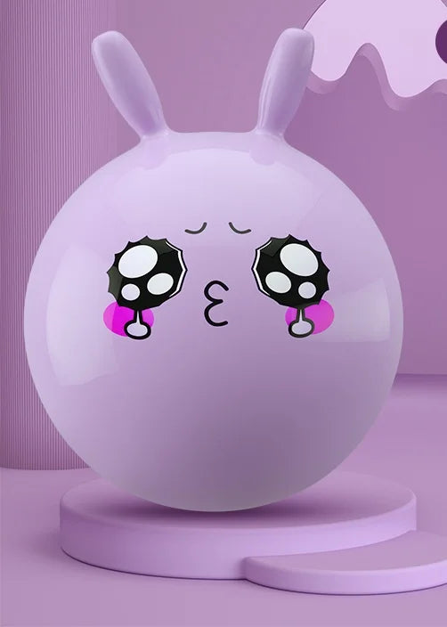 A smooth, light purple inflatable hopper ball with black and white spotted features rests on a pink stand.