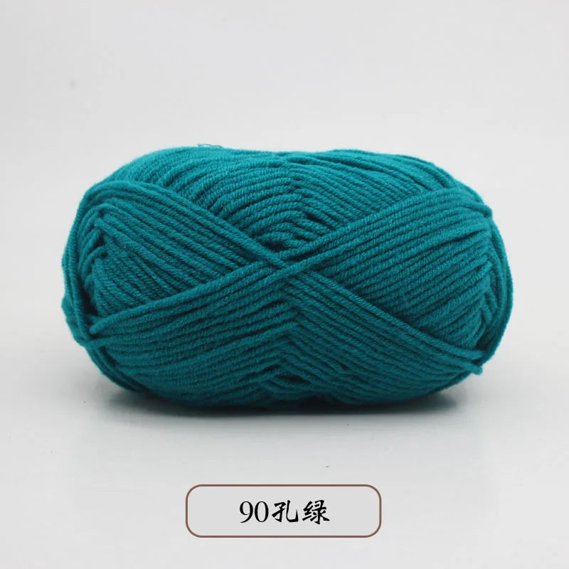 A ball of teal pre-dyed milk cotton yarn used for knitting and crochet.
