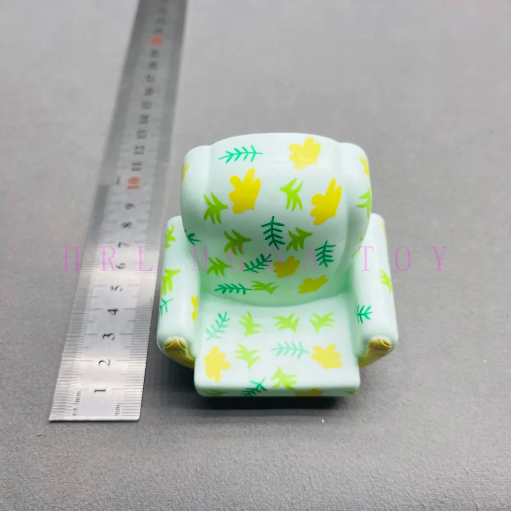 A light green PVC figurine shaped like a school bus with yellow cartoon watermelon designs.
