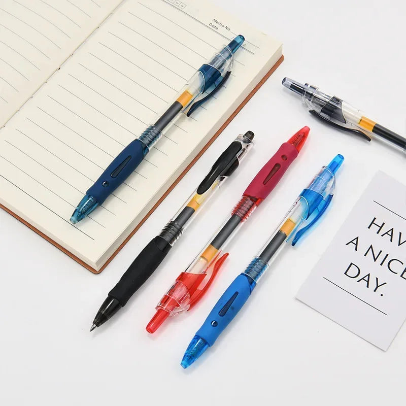 A collection of blue, black, and red retractable gel pens are displayed on a lined notebook page.