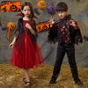A young girl in a red vampire costume with a black cape and a young boy in a dark bat-themed costume.