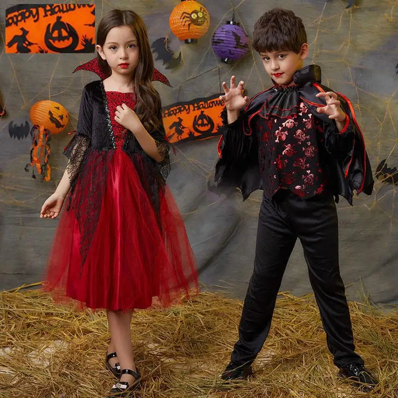 A young girl in a red vampire costume with a black cape and a young boy in a dark bat-themed costume.