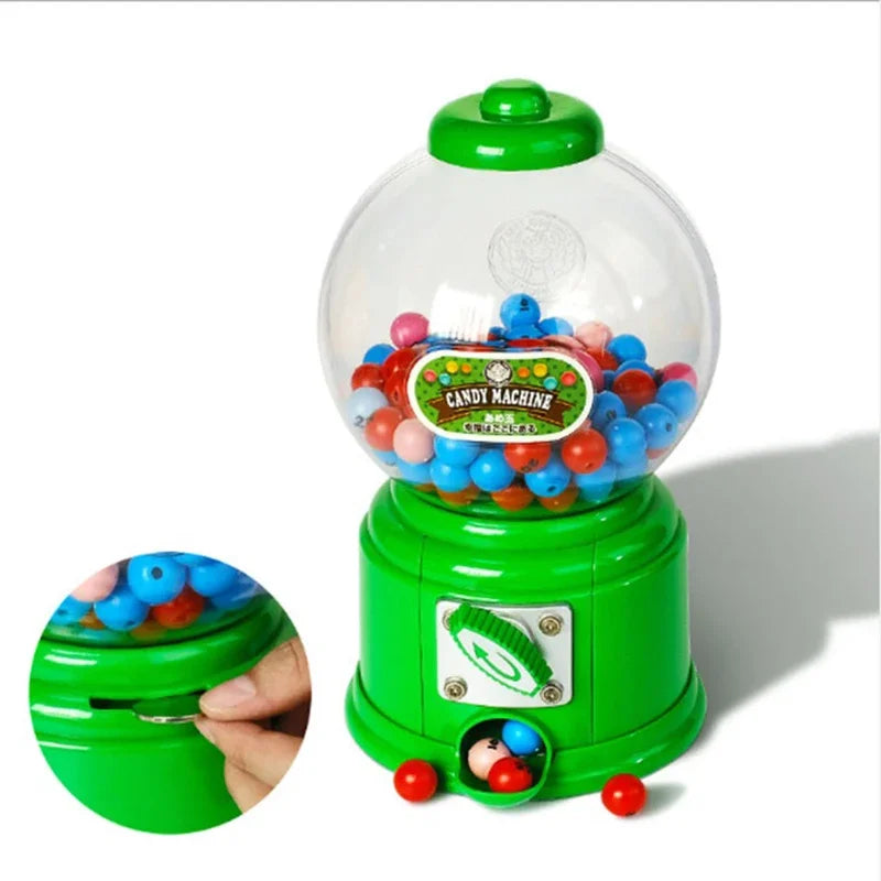 A green and clear plastic candy machine dispenser filled with colorful gumballs, shown next to a hand.