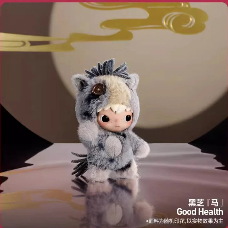 A small, gray and white fluffy plush doll with large eyes is displayed against a light background.