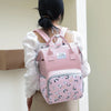 A woman is shown from the back carrying a pink Mommy backpack with a floral pattern.
