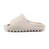 A beige EVA platform slide with a textured sole is shown from a side angle.