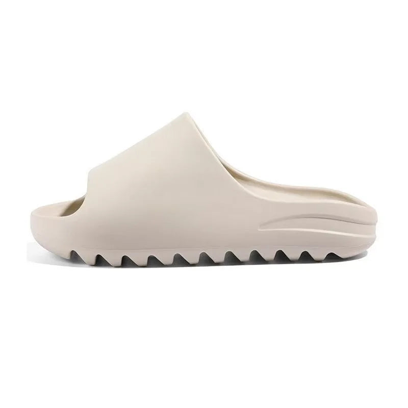 A beige EVA platform slide with a textured sole is shown from a side angle.
