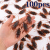A hand holds numerous lifelike fake cockroaches for props and Halloween