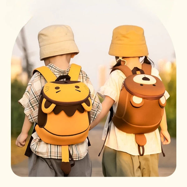 Two children wearing orange toddler anti-lost backpacks with safety straps walking outdoors.