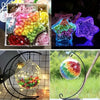 A collection of colorful origami star paper strips and a glass ornament display featuring various iridescent colors.