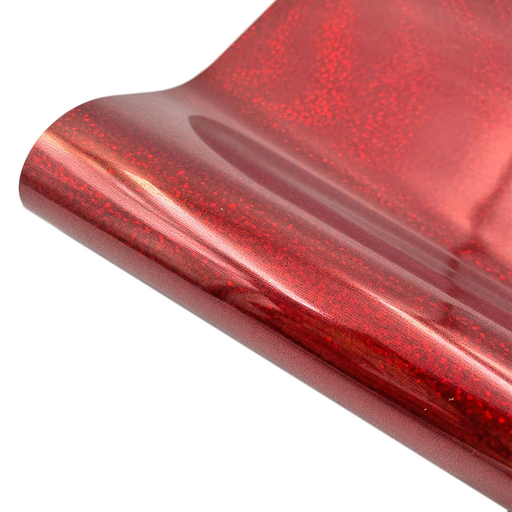 Close-up of a red glitter holographic heat transfer vinyl sheet rolled up.