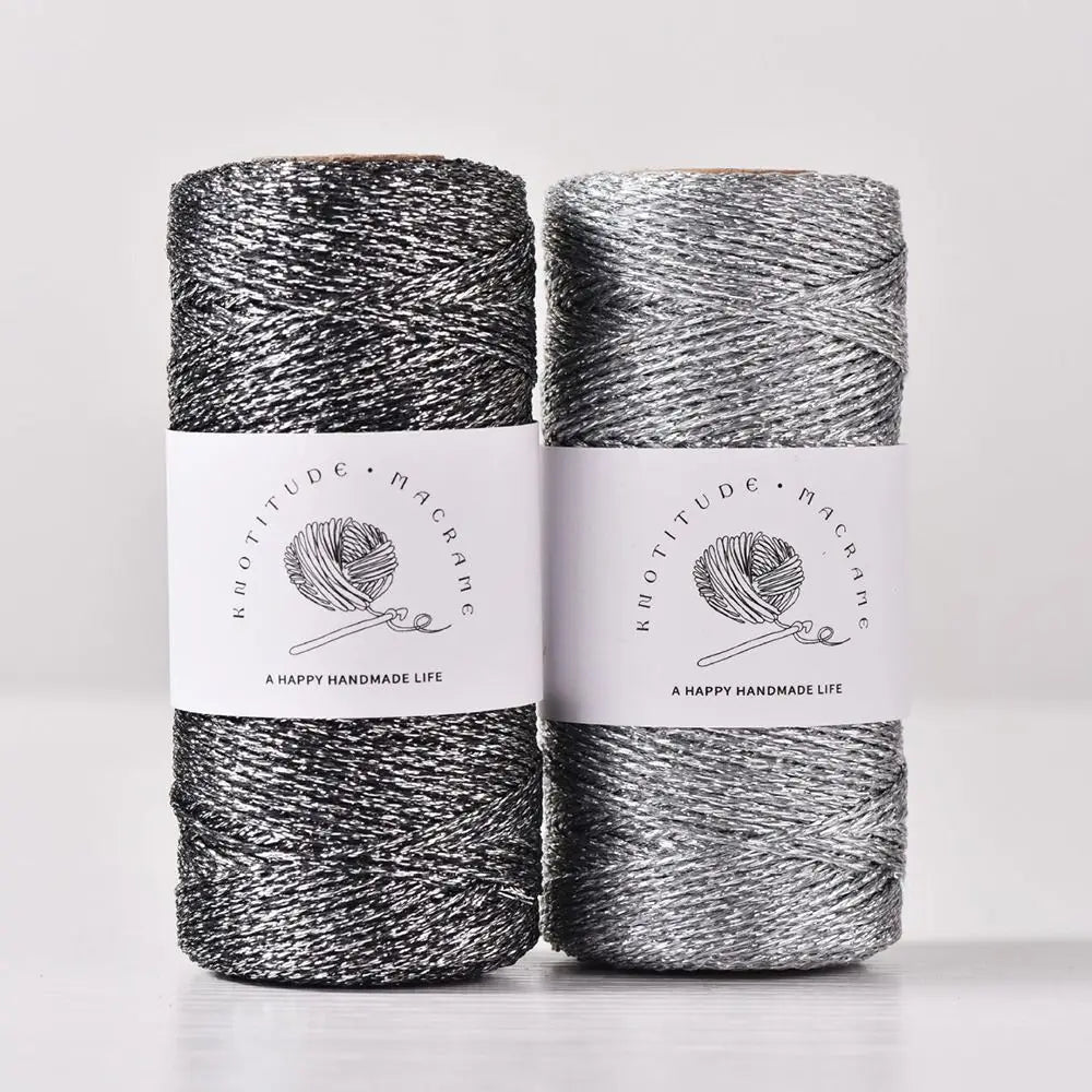 Spools of metallic yarn for knitting and crochet with black and silver threads.