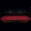 A set of three red quilted car seat cushions with black trim and fasteners shown in a dark interior.