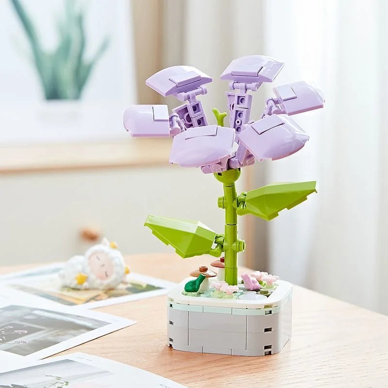 A purple rose flower building block bouquet set with green stems and white base on a wooden table.
