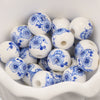 A collection of small white ceramic beads decorated with blue floral patterns for jewelry making