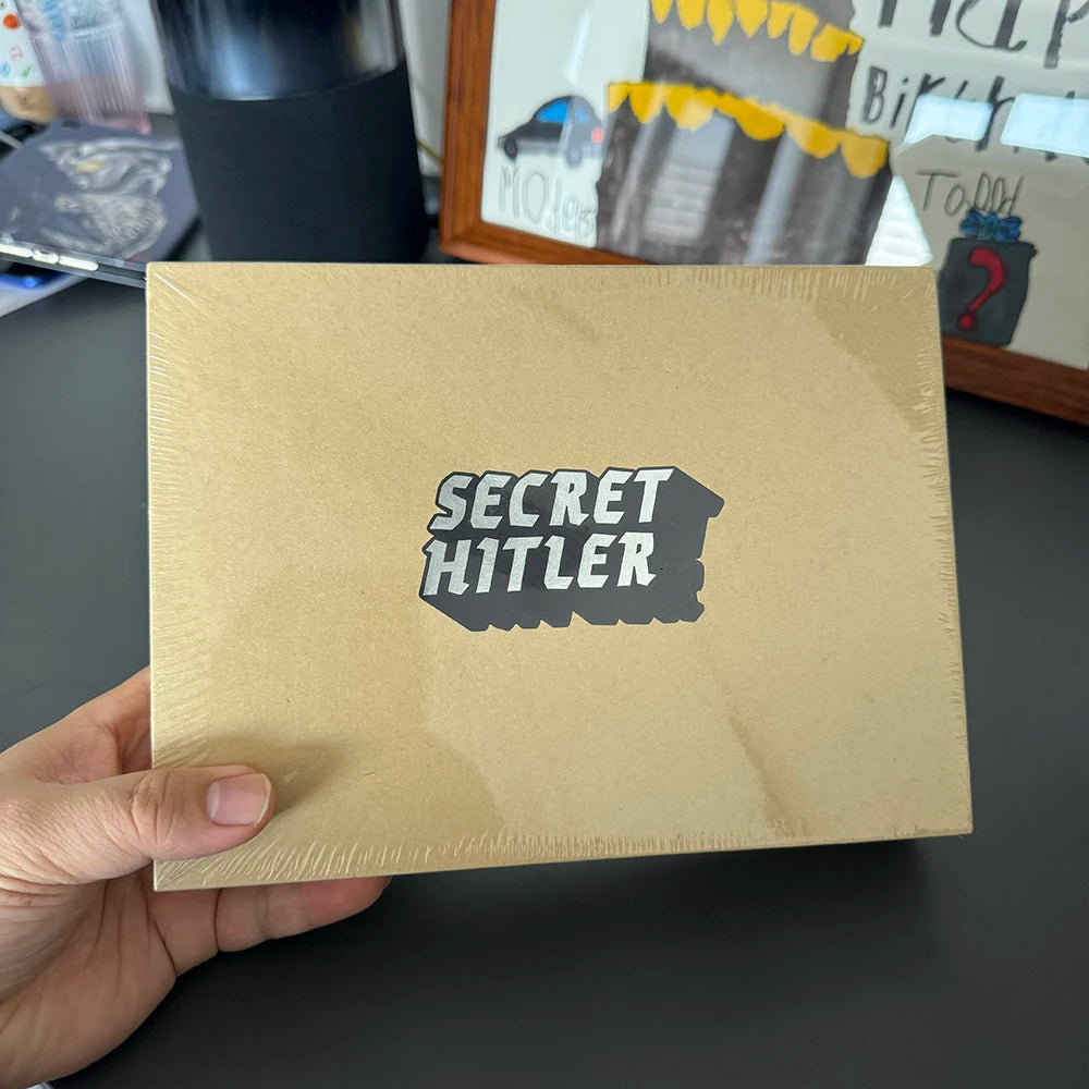 A brown envelope with the text SECRET HITLER printed on it, held by a hand.