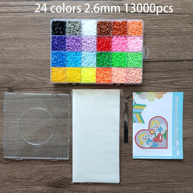 A collection of 24 colors of 2.6mm fuse beads in a plastic tray and a sheet of white material.