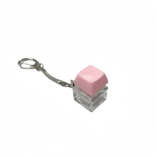 A pink, translucent cube fidget toy attached to a silver keychain.