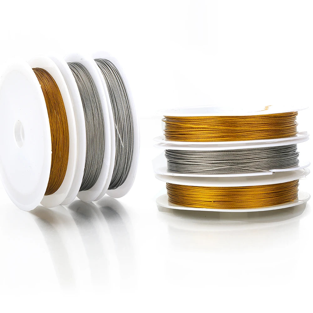 Rolls of stainless steel beading wire in gold and silver colors displayed on a white surface.