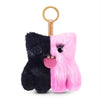 A black and pink fluffy alien plush keychain with a gold ring.