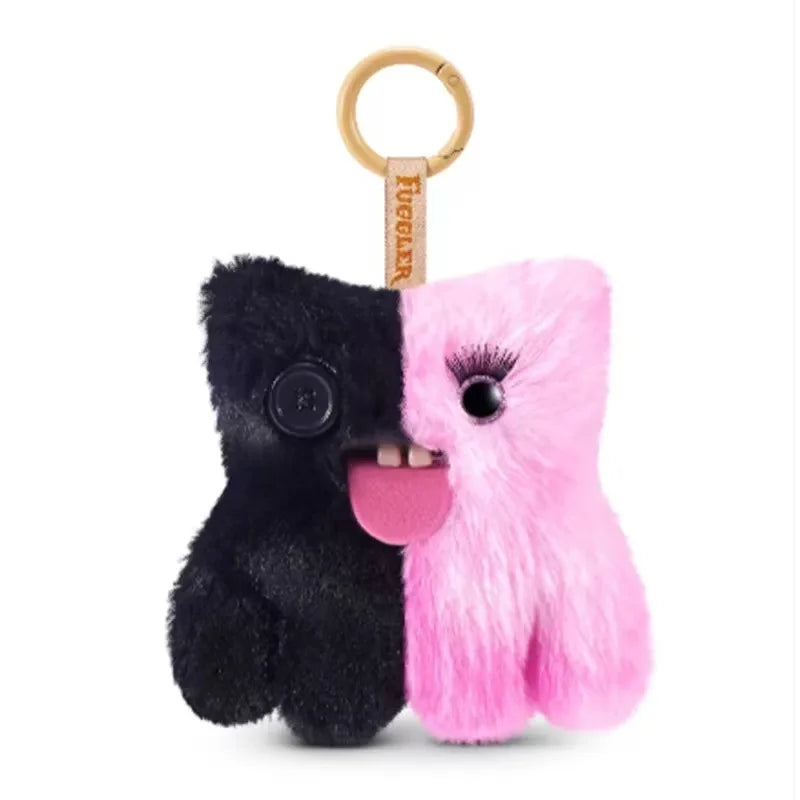 A black and pink fluffy alien plush keychain with a gold ring.