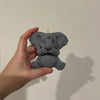 A hand holds a gray silicone mold shaped like an elephant for crafting.