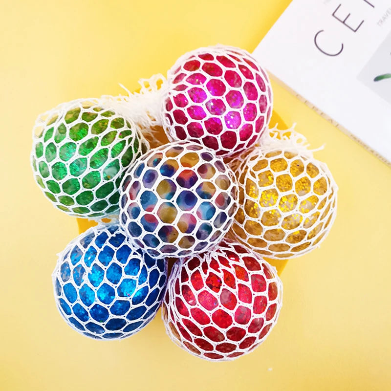 A collection of colorful stress relief balls with mesh netting in various vibrant colors like green, pink, blue, and yellow.