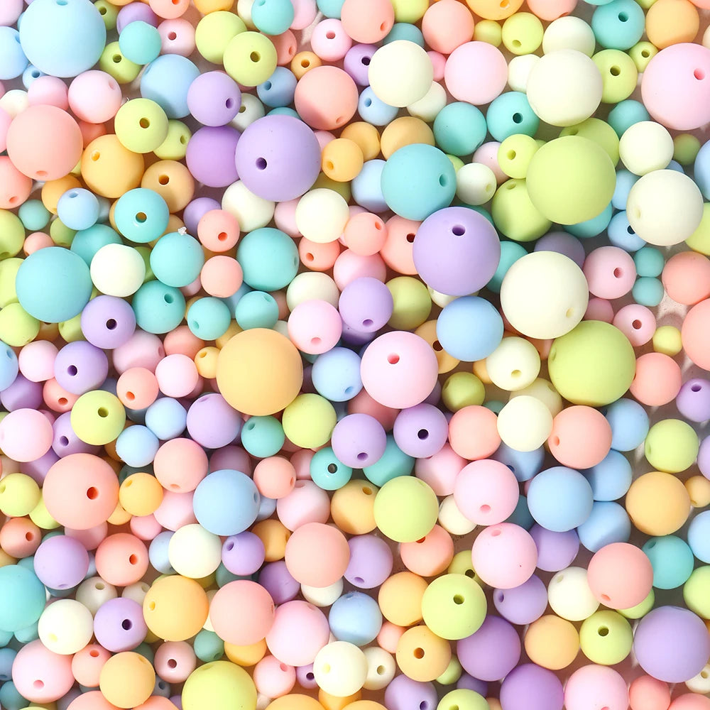 A close-up view of a large pile of colorful matte acrylic beads in various pastel shades.