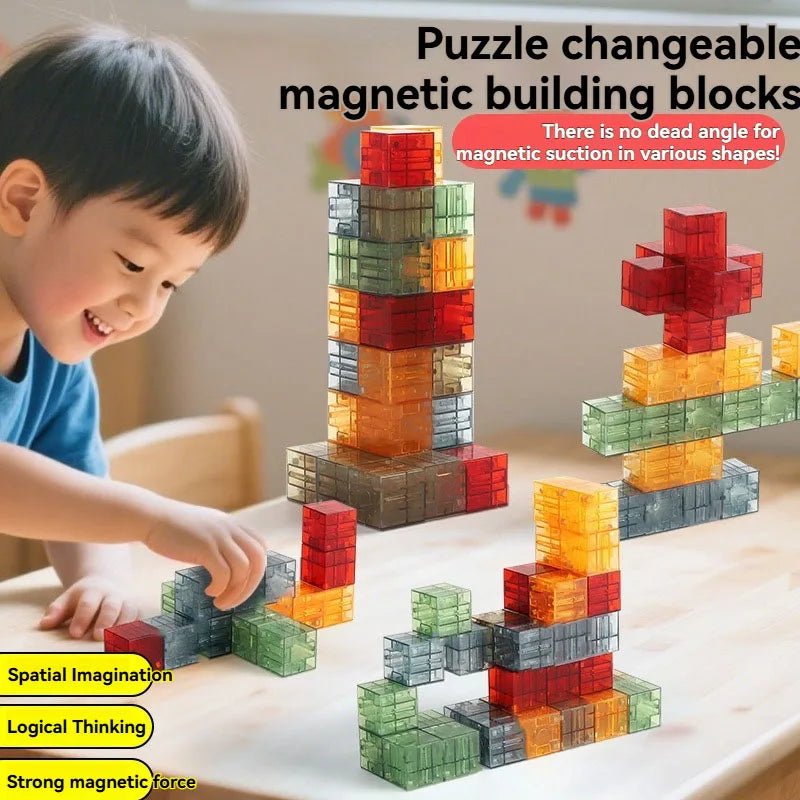 A child is building a tower with colorful magnetic building blocks on a wooden table.