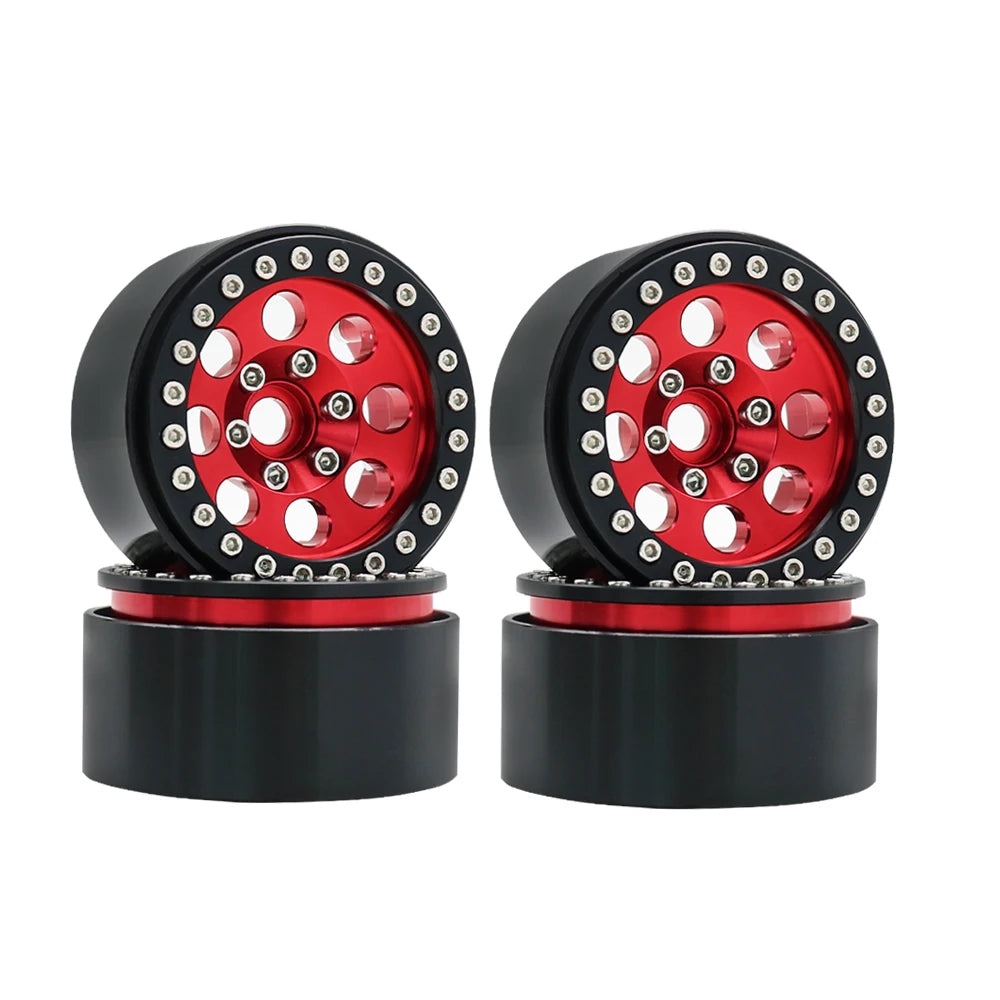 A pair of black metal beadlock wheels with a red center and removable hex hub for an RC crawler.