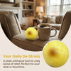 A yellow fluid potato squishy toy resting on a desk next to a cup of coffee.