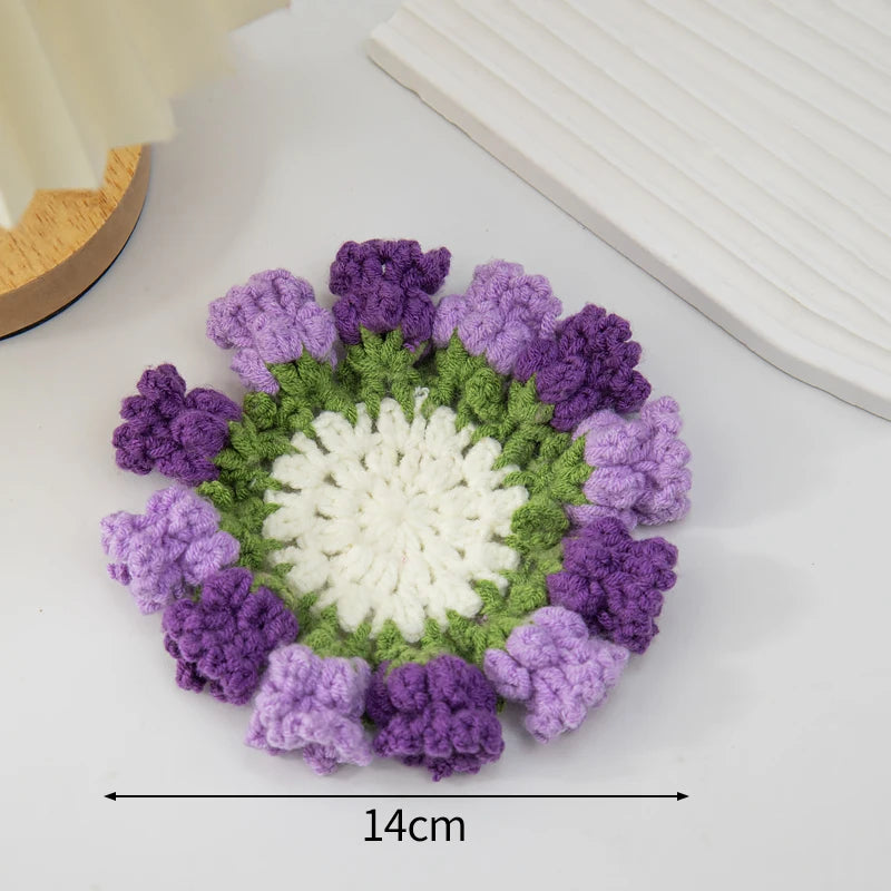 Hand-crocheted lily of the valley coasters featuring purple and green yarn petals