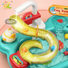 A yellow plastic kitchen sink toy with a curved spout and various colorful plastic fish toys is being washed under running wa