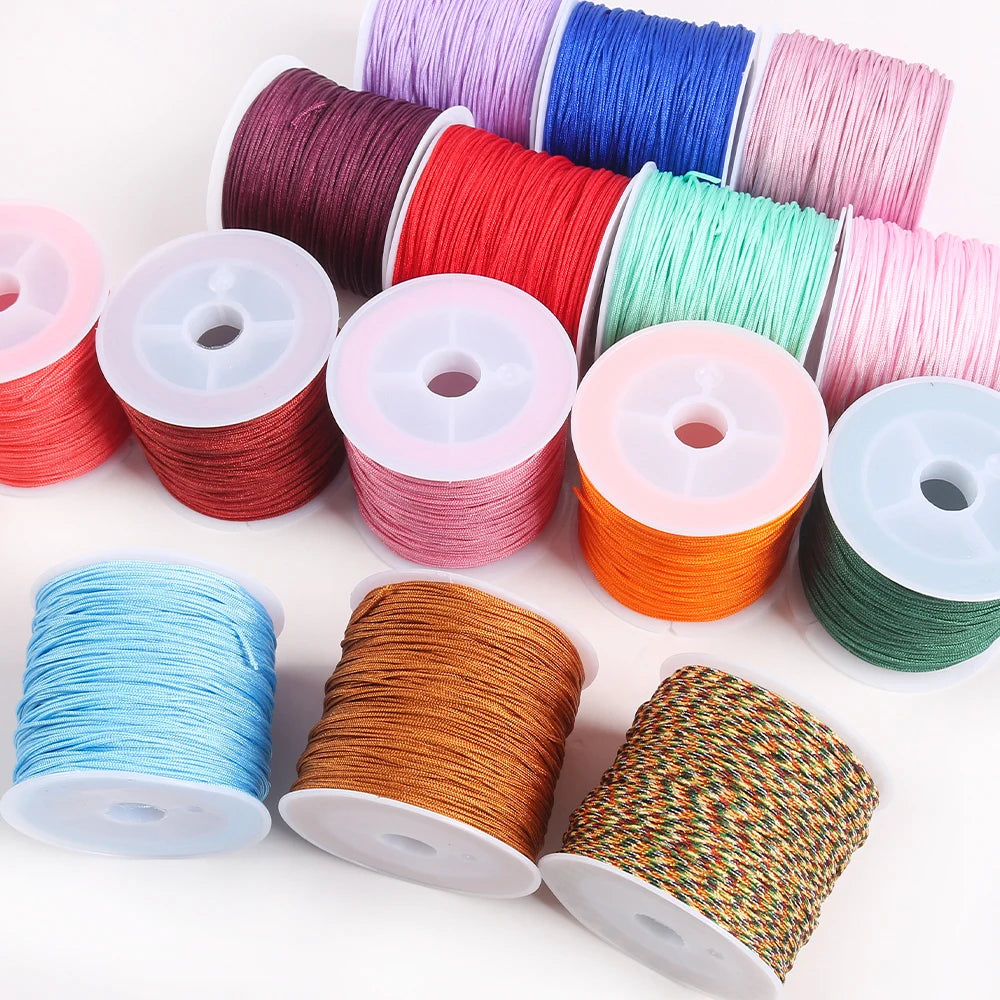 A collection of colorful 0.8mm cotton nylon macrame cord rolls in various shades and colors for jewelry making and crafts.