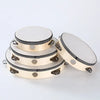 A round wooden tambourine with metal jingles, shown from the top view.