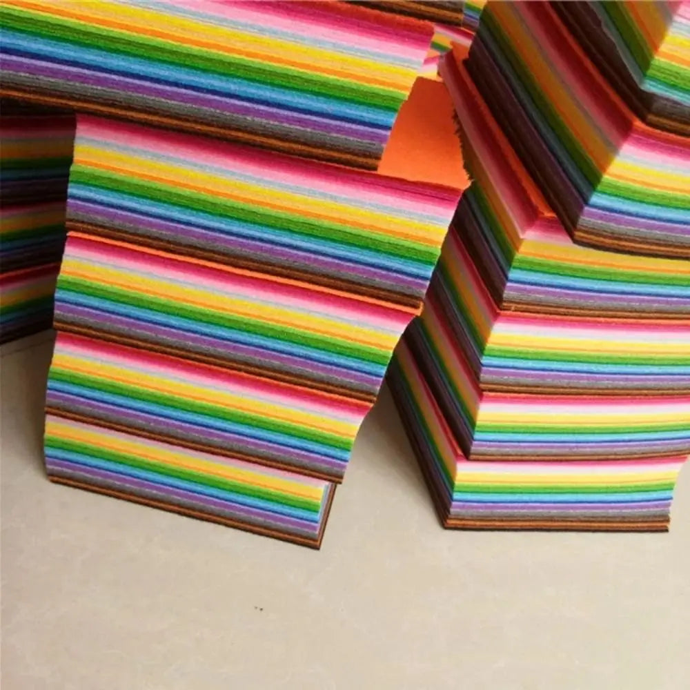 A stack of vibrant felt fabric sheets in a rainbow color spectrum, showing various stripes and colors.