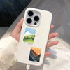 A white smartphone features a decorative sticker pack depicting a landscape with mountains and the sea.