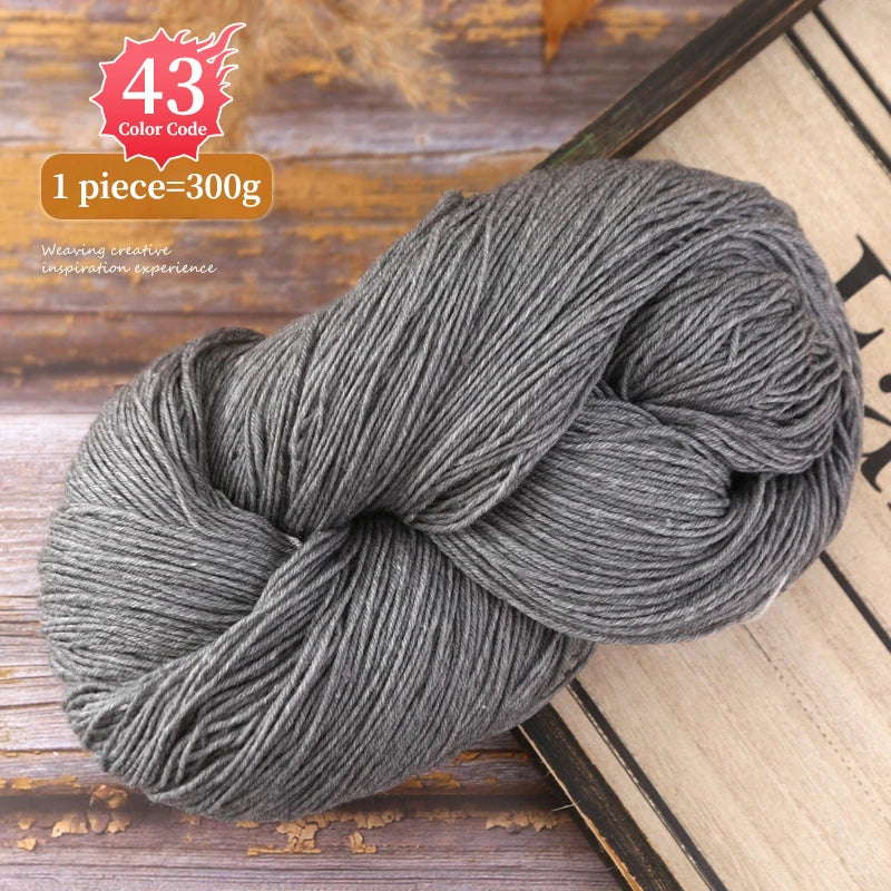 A ball of gray premium alpaca blend yarn is shown on a wooden surface.