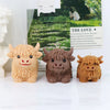 Three silicone molds of Highland cows in various shades of brown and tan used for candles, soap, and crafts.