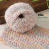 A ball of soft, fluffy pink and white alpaca blend yarn used for knitting or crochet projects.