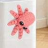 A pink 3D printed articulated octopus fridge magnet with textured skin and black eyes.