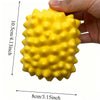 A bright yellow, textured squishy stress ball is held in a hand, showing its size and surface detail.