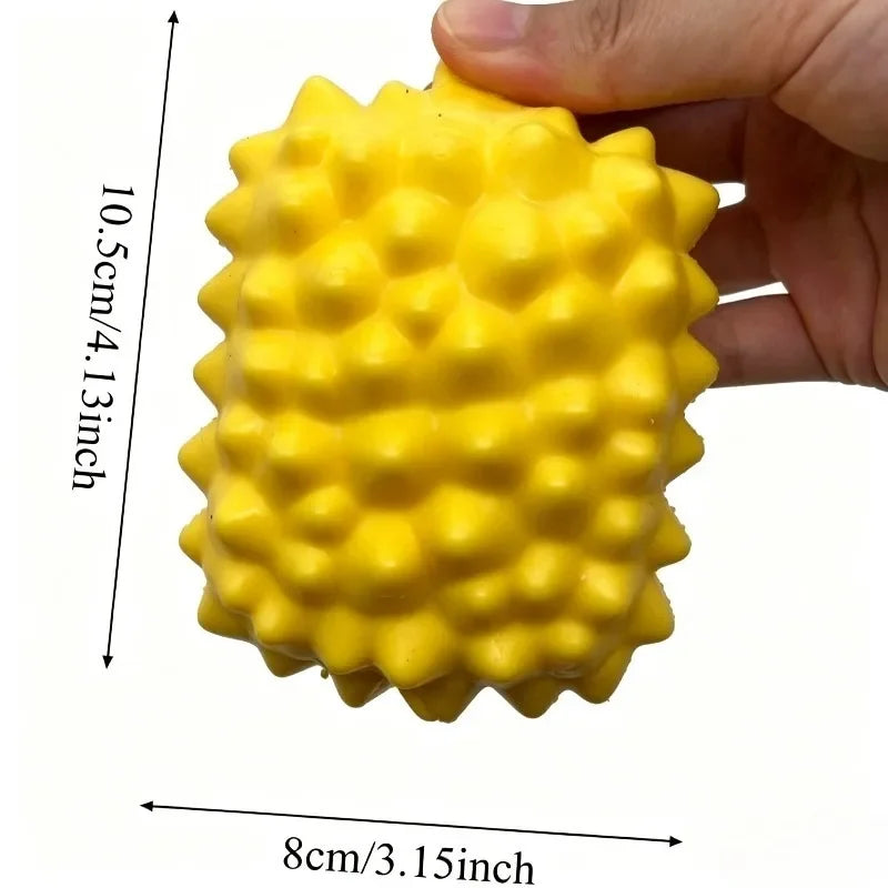 A bright yellow, textured squishy stress ball is held in a hand, showing its size and surface detail.