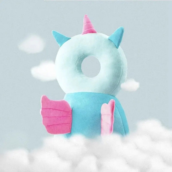 A light blue plush unicorn head pillow with pink accents floating above white clouds.